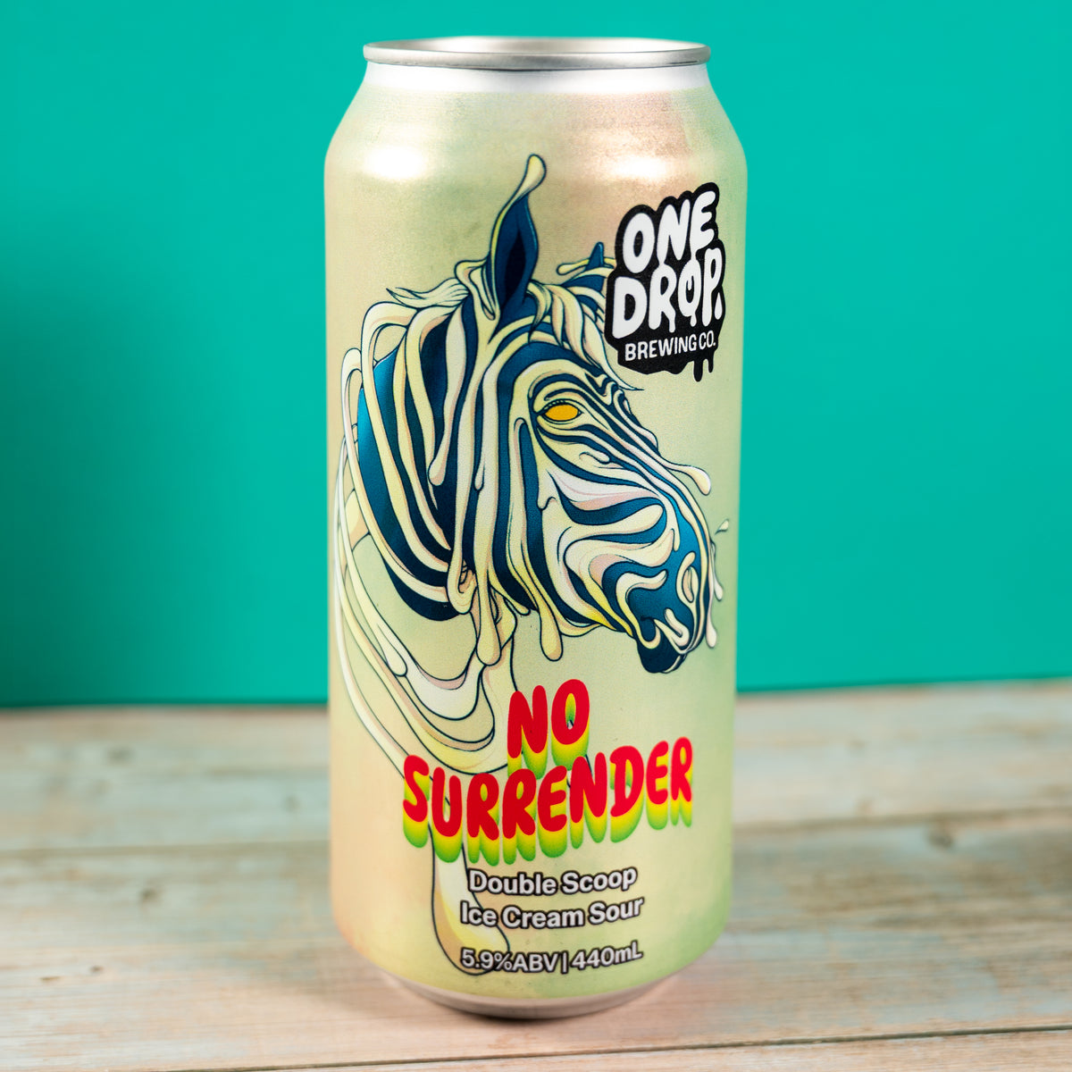 A single aluminum beverage can from One Drop Brewing Co. featuring a stylized zebra illustration and the text 'No Surrender' on a turquoise and wood surface.